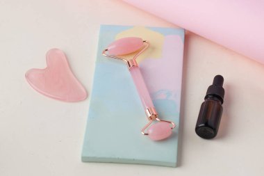 Organik cilt bakımı. Gül kuvars yşa taşı, yeşim silindir ve cam düşürücü şişe. Çevre dostu cilt bakımı