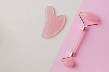 Düz bir gül kuvars yasa taşı, hafif bir arka planda yeşim taşı. Evde cilt bakımı kavramı. Boşluğu kopyala.