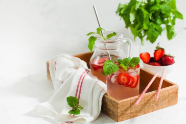 Sürahi ve bardakta ev yapımı taze çilekli limonata.