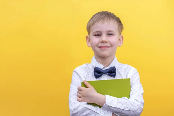 Roztomilý chlapeček ve školní uniformě s batohem se podívá do kamery, 1. září. Zpět do školy. — Stock fotografie