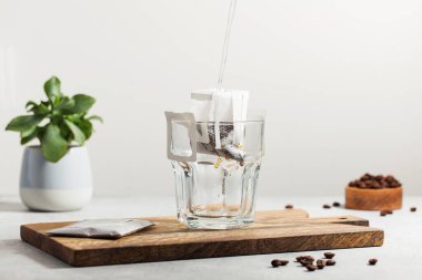 Kahve demleme süreci. Su, kupanın içindeki kahve torbasına dökülüyor. Evde kahve demleme eğilimleri.