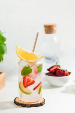 Hafif arka planda çilek, limon ve nane aromalı ferahlatıcı bir yaz içeceği. Çilekli limonata.