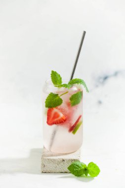 Hafif arka planda çilek, limon ve nane aromalı ferahlatıcı bir yaz içeceği. Çilekli limonata.