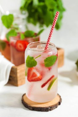 Hafif arka planda çilek, limon ve nane aromalı ferahlatıcı bir yaz içeceği. Çilekli limonata.