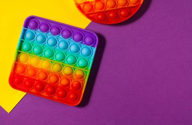 Renkli arka planda oyuncak silikon kullan. Stres önleyici oyuncaklar, çocuk oyuncaklarında moda. Boşluğu kopyala.