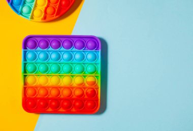 Renkli arka planda oyuncak silikon kullan. Stres önleyici oyuncaklar, çocuk oyuncaklarında moda. Boşluğu kopyala.