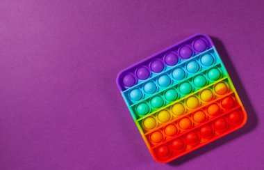 Mor arka planda oyuncak silikon kullan. Stres önleyici oyuncaklar, çocuk oyuncaklarında moda. Boşluğu kopyala.