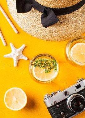 Yaz limonatası, hasır şapka, denizyıldızı, sarı arka planda kamera. Piknik konsepti, yaz tatili..