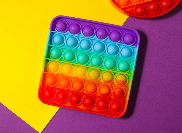 Pop it jouet silicone sur un fond coloré. Jouet anti-stress, une tendance dans les jouets pour enfants. Espace de copie. — Photo