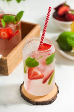 Hafif arka planda çilek, limon ve nane aromalı ferahlatıcı bir yaz içeceği. Çilekli limonata.