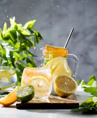 Limonata limonata ve naneli sürahi ve bardakta su sıçraması. Yaz içkileri. Boşluğu kopyala.