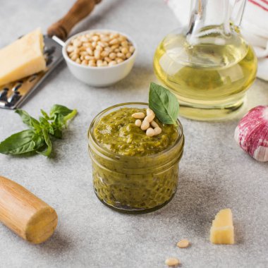 Kavanozda pesto sosu, bir parça parmesan peyniri, fesleğen yaprağı, çam fıstığı ve zeytinyağı. İtalyan mutfağı