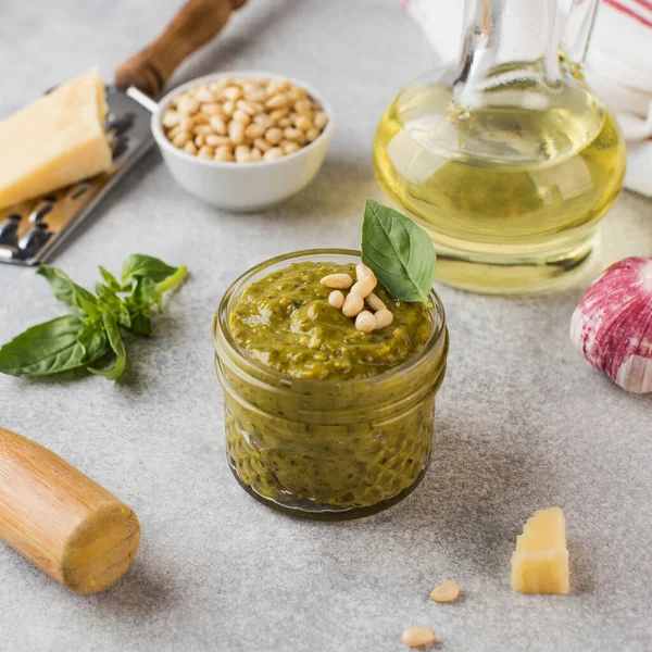 Kavanozda pesto sosu, bir parça parmesan peyniri, fesleğen yaprağı, çam fıstığı ve zeytinyağı. İtalyan mutfağı