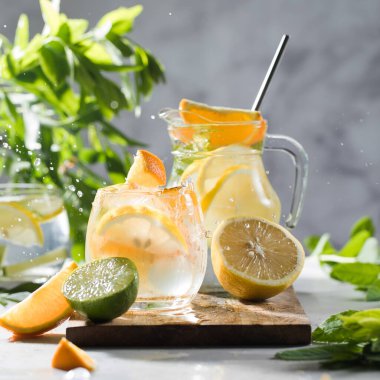 Limonata limonata ve naneli sürahi ve bardakta su sıçraması. Yaz içkileri. Boşluğu kopyala.
