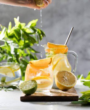Limonata limonata ve naneli sürahi ve bardakta su sıçraması. Yaz içkileri. Boşluğu kopyala.