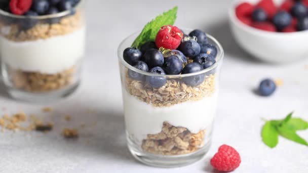 Honey is poured on granola with fresh berries. Breakfast. — Stok Video