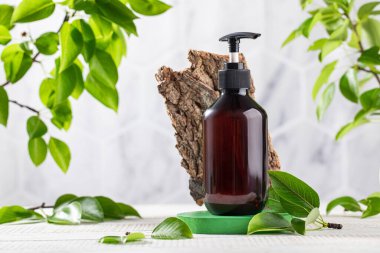 Kahverengi bir şeker kutusunda yeşil yapraklar ve ağaç kabuğundan oluşan organik kozmetik ürünler. Çevre dostu ürün.