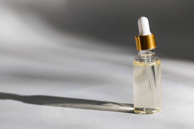 İçinde sıvı kozmetik ürünler olan cam damlatıcı şişesinin bir maketi. Yüz derisi için serum ya da yağ.