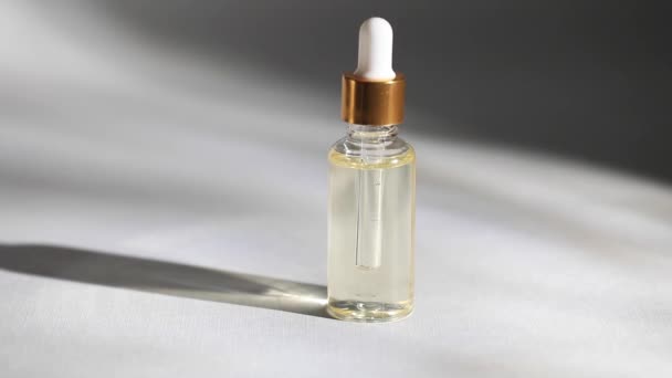 Egy üvegcseppes üveg makettje. Egy olajos csepp esik le a kozmetikai pipettáról. — Stock videók