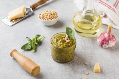 Kavanozda pesto sosu, bir parça parmesan peyniri, fesleğen yaprağı, çam fıstığı ve zeytinyağı. İtalyan mutfağı