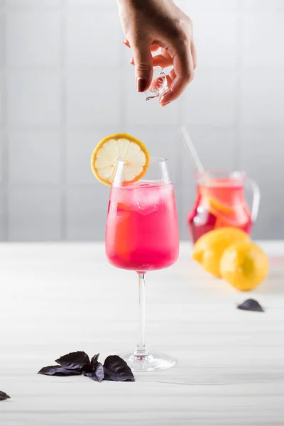 Limonada refrescante hecha de albahaca roja y limón en un vaso sobre un fondo claro. Una bebida de verano. — Foto de Stock