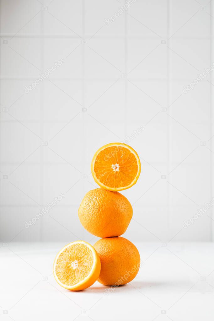 Still life balance of oranges on a white background. Copy space.