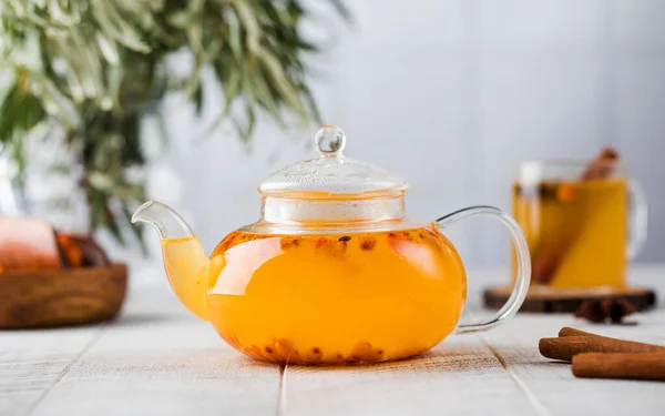 Autumn sea buckthorn tea in a teapot on a white wood background. Suasana musim gugur. — Stok Foto