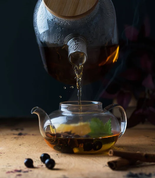 Teko dengan teh hitam dengan buah currant, lemon, tongkat kayu manis. Latar belakang musim gugur. Salin ruang. — Stok Foto