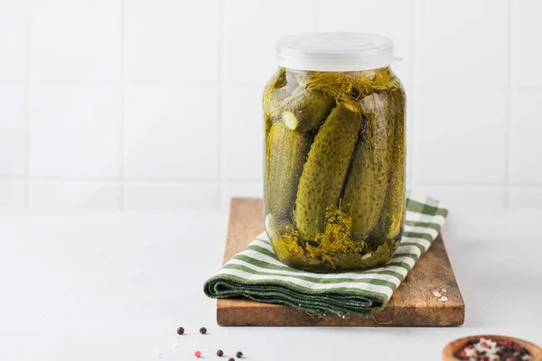 Pickled cucumbers in jars on a white background. Canning vegetables. Copy space. — Stock Photo, Image