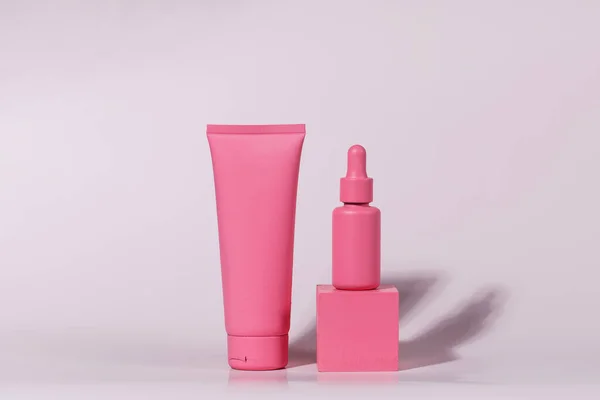 Mockup van roze containers voor cosmetica, crème, serum, gel op een roze achtergrond. Kopieerruimte. — Stockfoto