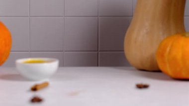 Bir kadın masaya krem şanti ve tarçınlı balkabaklı latte koyar..