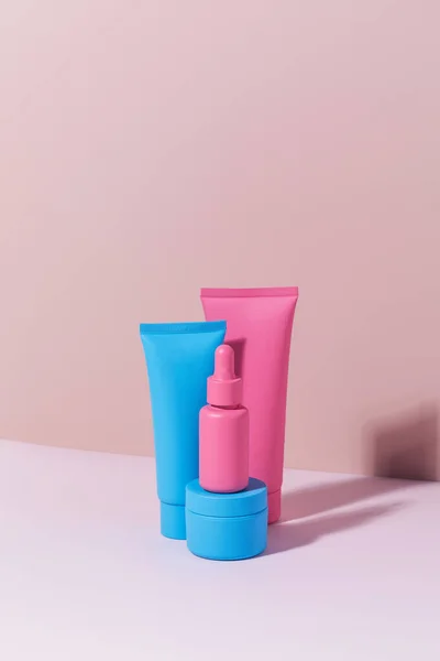 Různé mokups kosmetických lahví na růžovém pozadí. Trendy v péči o pleť. — Stock fotografie