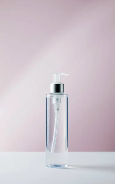 Uma maquete de um produto cosmético em um fundo rosa. Tónico de limpeza para o rosto, água micelar. Espaço de cópia. — Fotografia de Stock