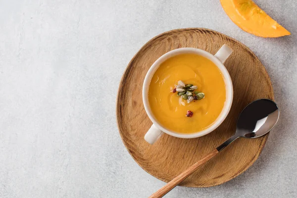 Sup krim labu dalam mangkuk dengan biji di latar belakang abu-abu. Menunggang dengan nyaman, menu musim gugur. Salin ruang, — Stok Foto