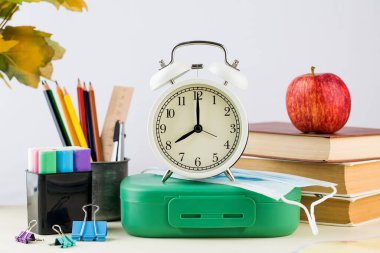 Okula dönelim. Okul malzemeleri, çalar saat ve koruyucu maske bileşimi..