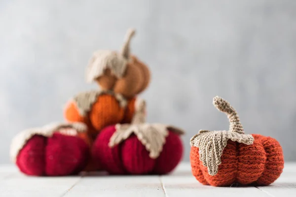 Handmade knitted pumpkins with leaves on white table — Stock Photo, Image
