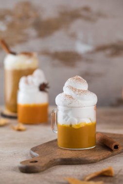 Balkabağı arkaplanında kremalı balkabağı lattesi..