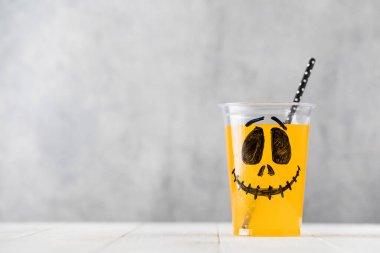 Komik, ürkütücü yüzlü ve samanlı bir bardakta iç.