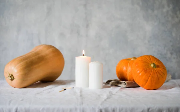 リネンのテーブルクロスにカボチャとろうそく。スタイリッシュな居心地の良い秋の表情。秋のコンセプト。感謝祭おめでとう。スペースのコピー. — ストック写真