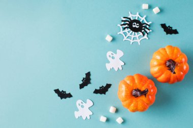 Cadılar Bayramı küçük balkabakları kağıt hayaletler ve turkuazda örümcekler ile süslenir.