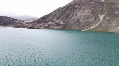 Scenic aerial journey over serene mountain lake and rolling hills in misty weather. New Zealand. Concept of travel and nature