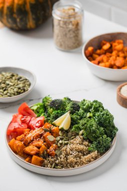 Besleyici bir yemek için kinoalı, balkabaklı ve sebzeli sağlıklı vegan Buda kasesi. Sebze tarifleri kavramı.