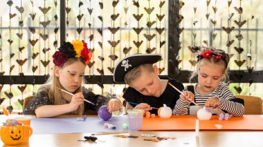 Kids making Halloween crafts in costume. Halloween craft workshop. Happy Halloween.