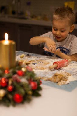 Caucasian male child baking christmas cookies in festive kitchen. Concept of Merry Christmas