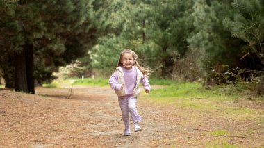 Joyful child running in natures forest pathway. Concept of nature