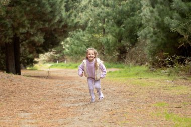Joyful child running in natures forest pathway. Concept of nature