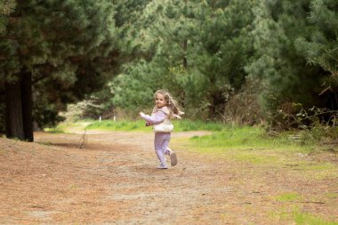 Joyful child running in natures forest pathway. Concept of nature