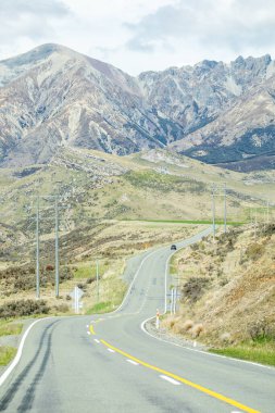 Macera yolculuğu tasarımı için engebeli arazide kıvrılan manzaralı dağ yolu. Yeni Zelanda