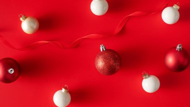 Parlak kırmızı arka planda Noel süsleri. Yeni yıl teması, parlak bir arka planda festival dekorasyonları. Yeni yıl ve Noel konsepti