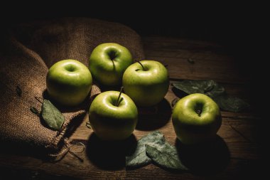 Bir çuval yeşil elma ve kırsal ahşap..